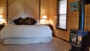 cabin-king-bed-wood-stove-window-horns-ferry-hideaway